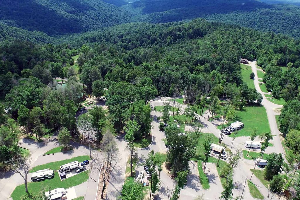 An aerial view of a campground in the mountains, surrounded by blooming flowers.
