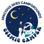 A circular logo with an astronaut holding a marshmallow on a stick under a crescent moon and stars. Text around the image reads “Spacious Skies Campgrounds Cosmic Camper.” Perfect for fans of the Spacious Skies Loyalty Program.