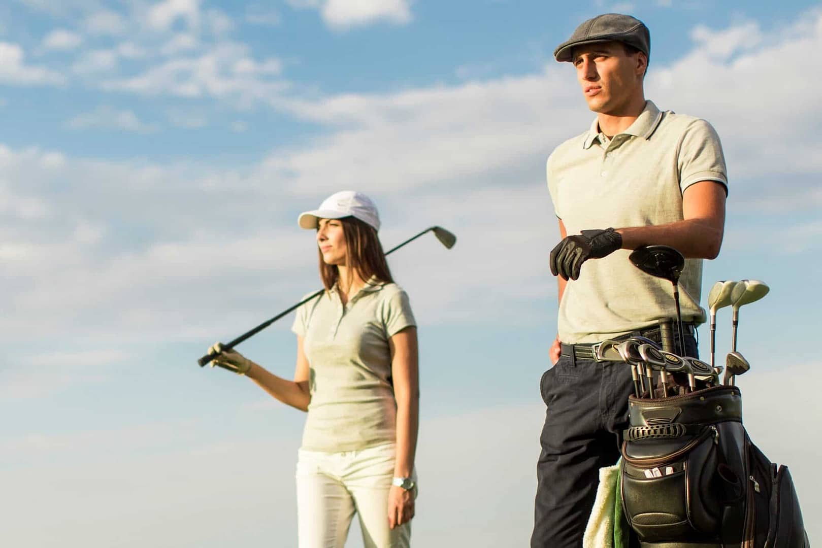 A man and woman standing next to each other on a blooming golf course.