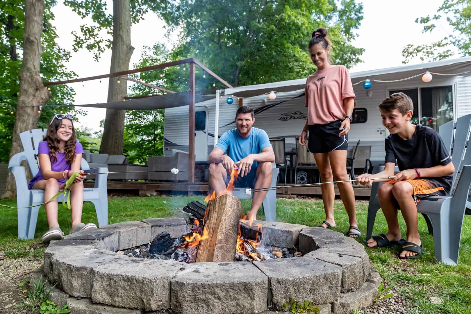 A group of people gathered around a fire pit in the spring.