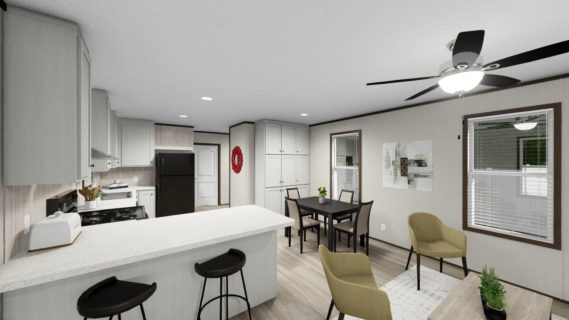 Modern open-concept kitchen and dining area with light cabinetry, a breakfast bar with stools, dining table, chairs, and ceiling fan; windows provide natural light.