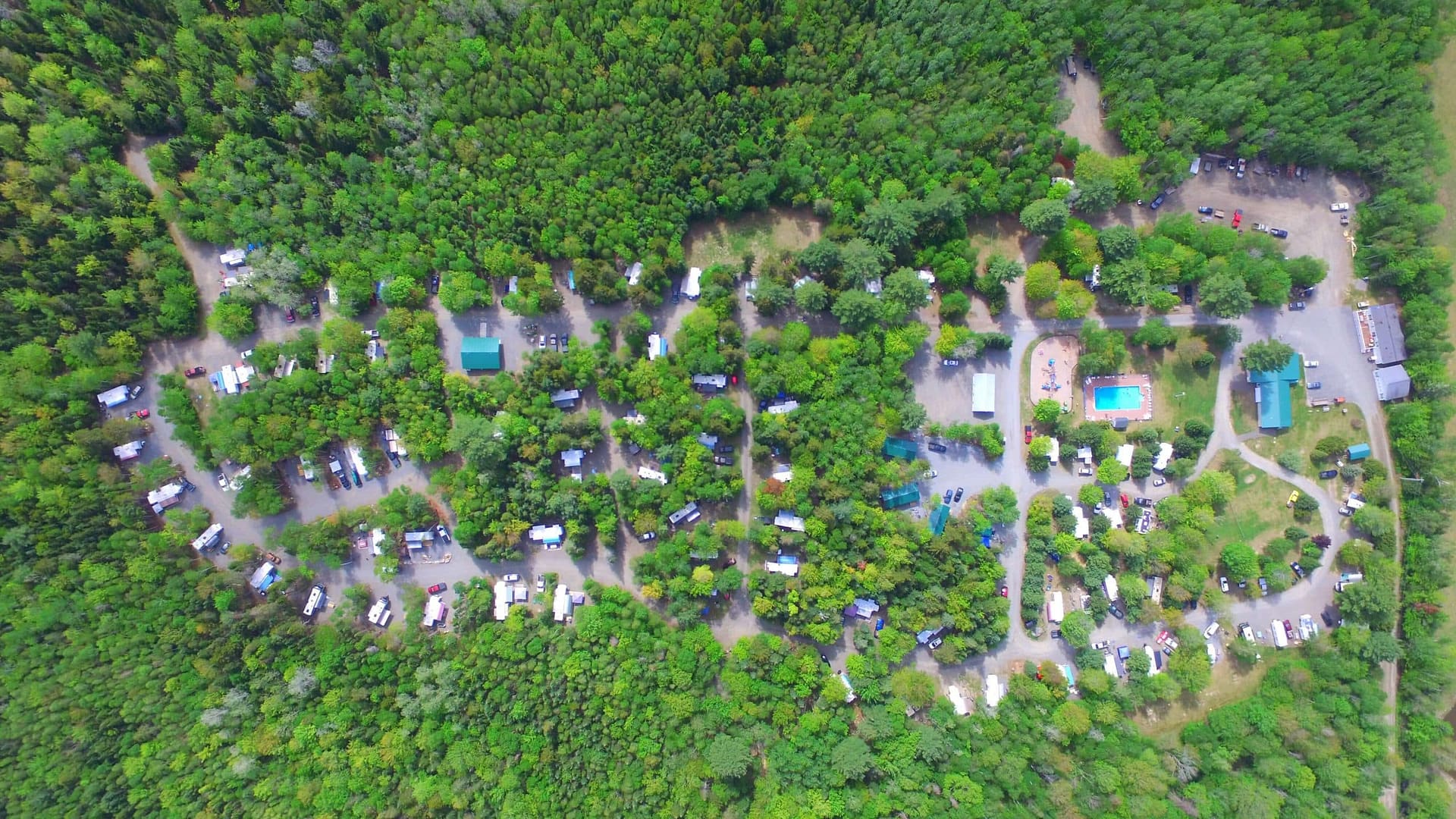 An aerial view of an RV park nestled among trees.