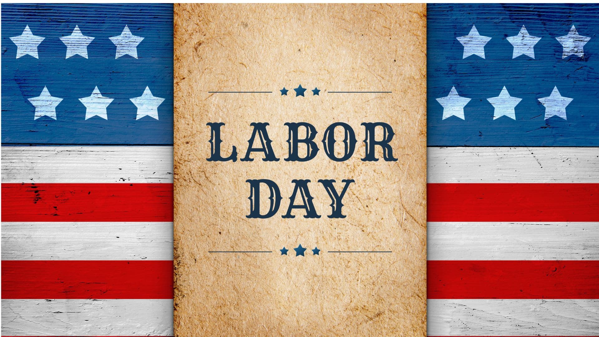 A rustic "Labor Day" sign is displayed on a tan textured background, flanked by red, white, and blue wooden panels with stars and stripes—a festive nod to a coastal summer celebration.