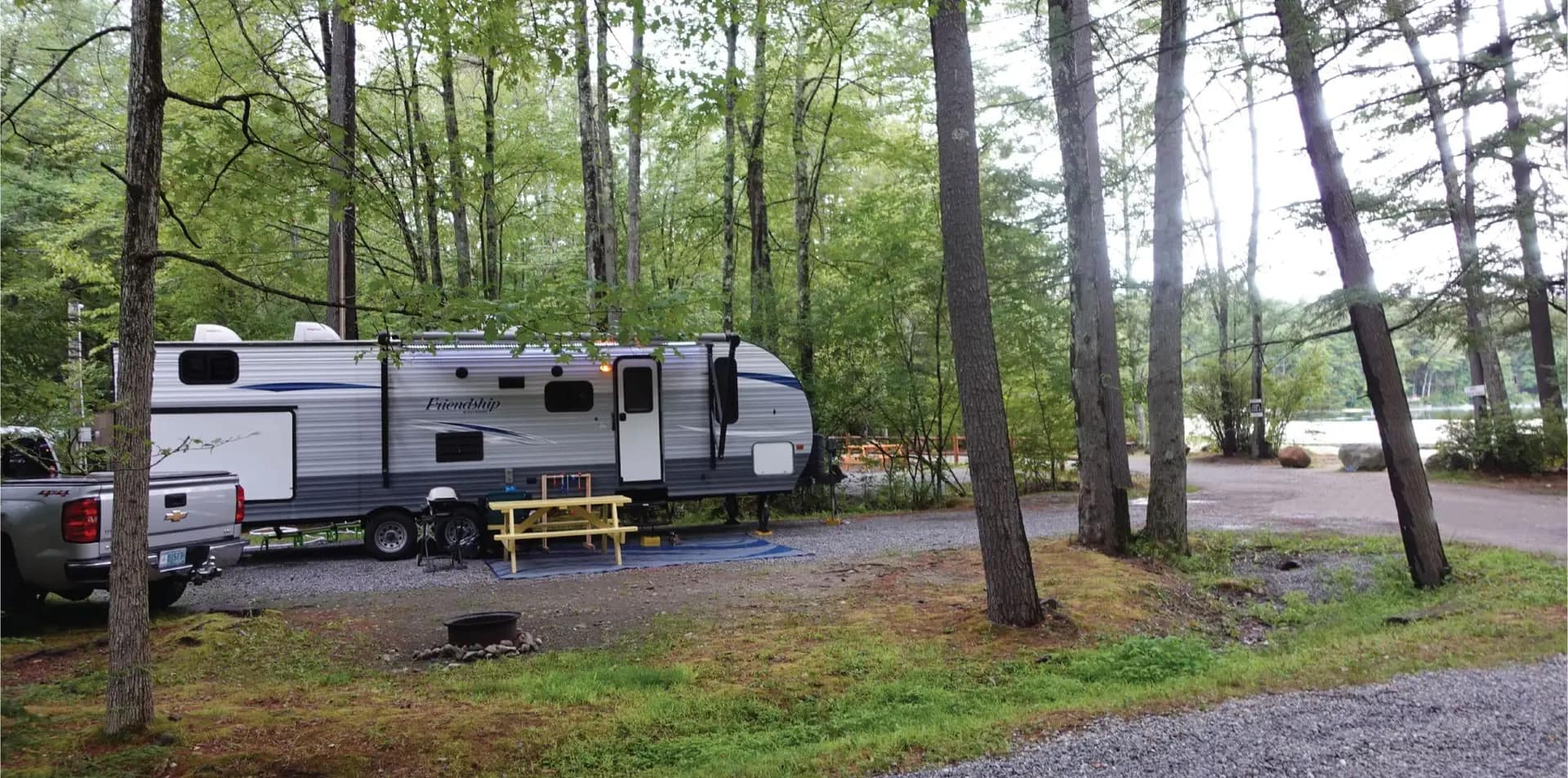 An RV parked in a wooded area with amenities.