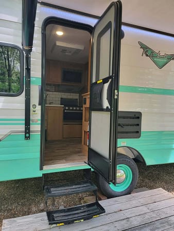 A camper with a door open.