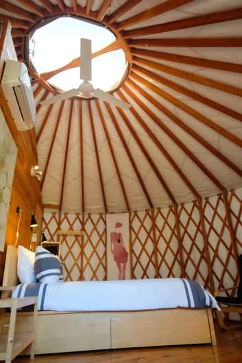 A room with a ceiling fan and a bed.