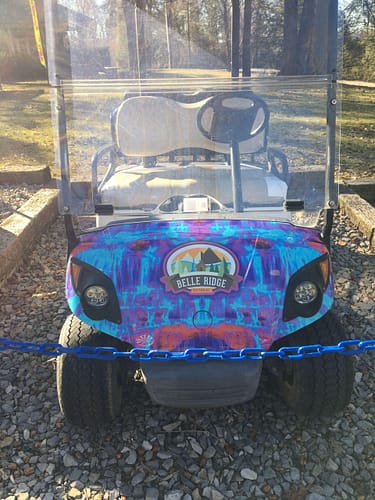 A golf cart parked on gravel.