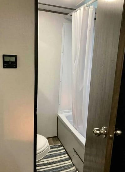 A small bathroom with a toilet and shower, perfect for camping.