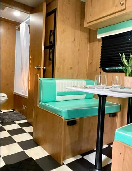 The RV interior features a checkered floor, perfect for camping enthusiasts.