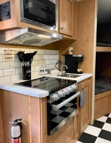 A small kitchen in an RV with a stove and sink.