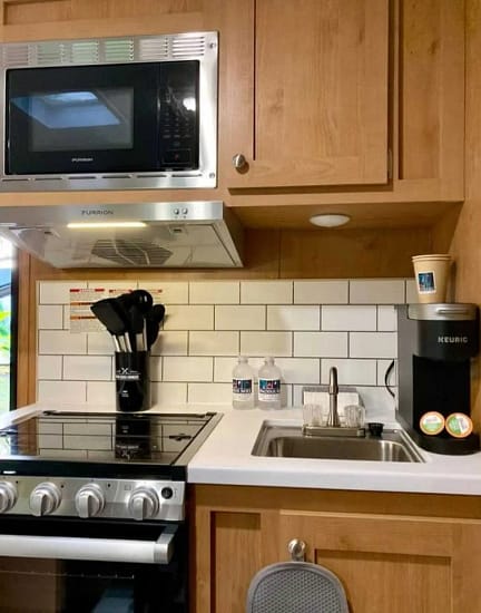 A kitchen with a stove and sink, perfect for use in an RV.