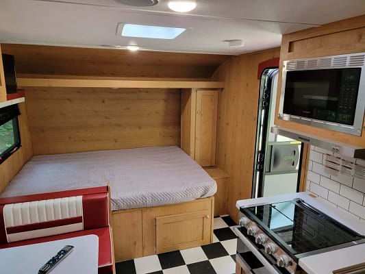 A small kitchen with a bed and a microwave.
