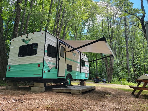 A rv parked in a forest.