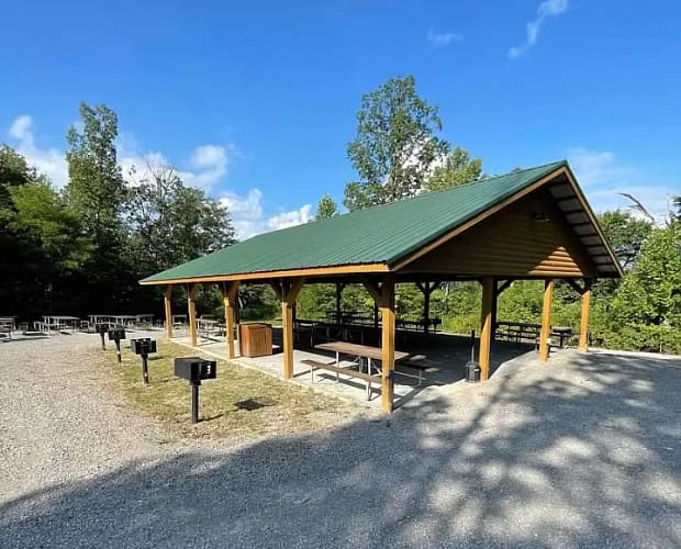 A picnic area with benches and a green roof.