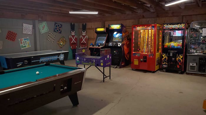 A room with arcade games and pool table.