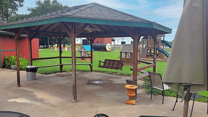 A gazebo with swings and swings in the background.