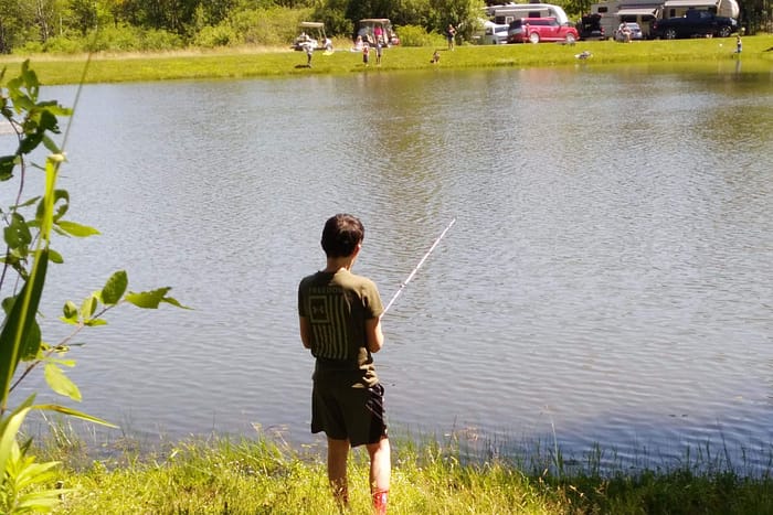 A boy fishing in a lake.