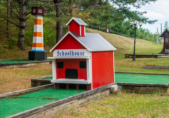 Miniature golf course with miniature houses and a lighthouse.