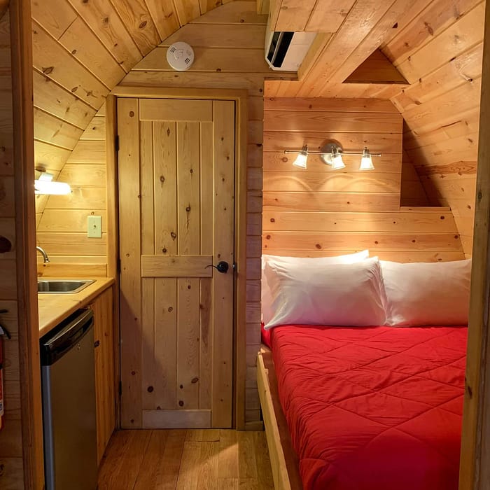 A room with a bed and a refrigerator.