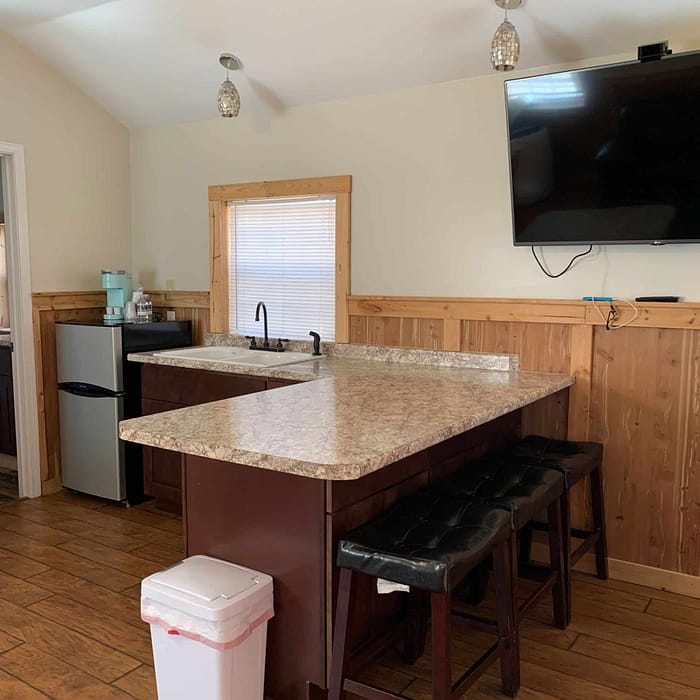 A kitchen with a bar and a television.