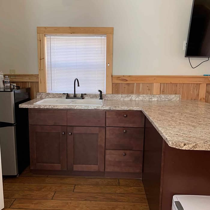 A kitchen with a sink and a television.