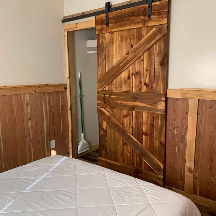 A bedroom with a sliding barn door.