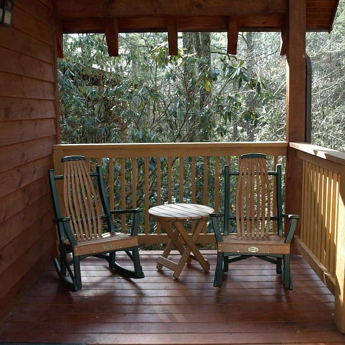 A wooden deck with chairs and a table.