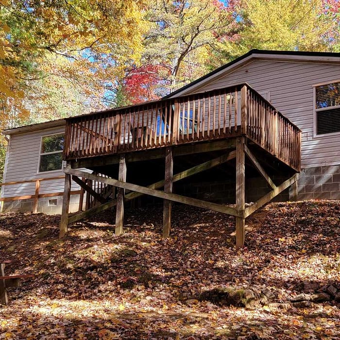 A house with a deck and a bench in the back.