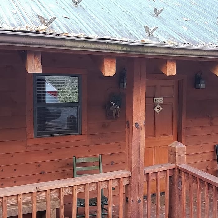 A wooden house with a porch and a porch railing.