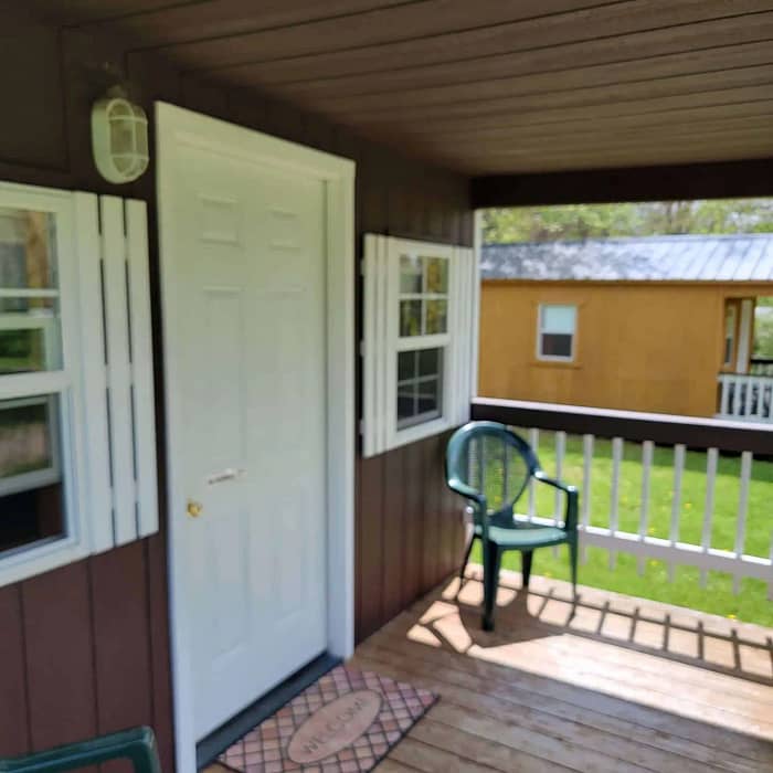 A porch with a chair and a door.