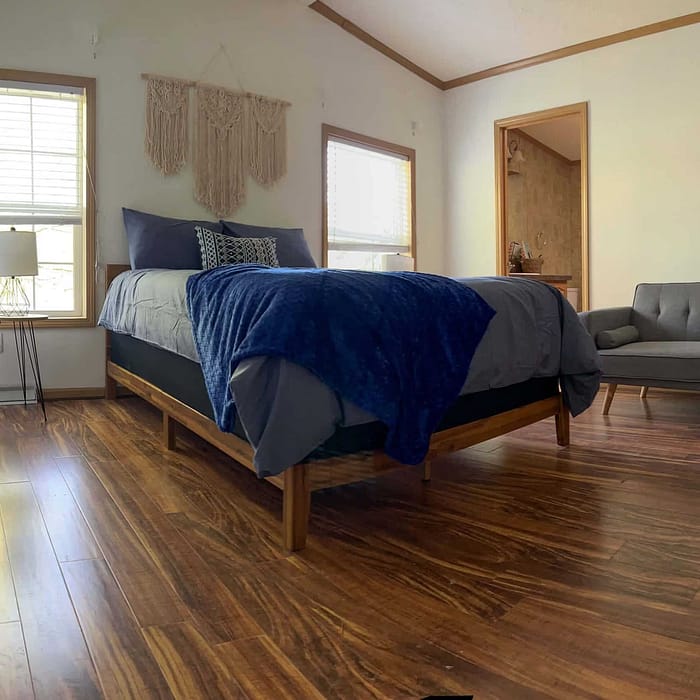 A bed or beds in a room with hardwood floors.