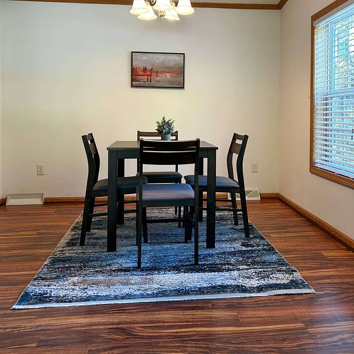 A dining room with hardwood floors and a table.