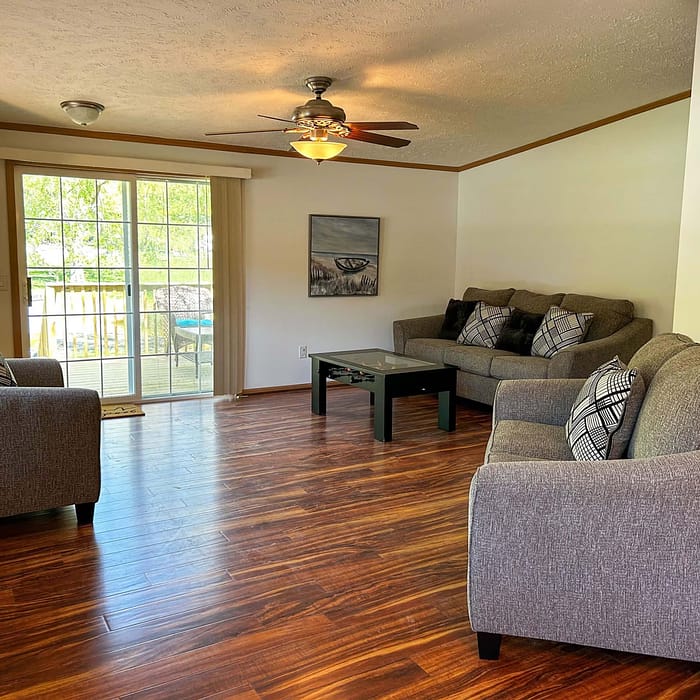 A living room with a wood floor and a ceiling fan.