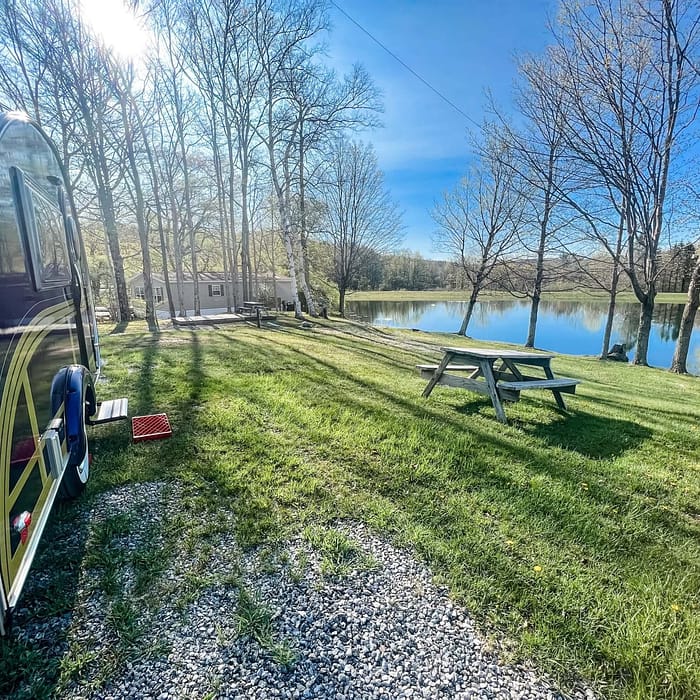 An airstream parked next to a lake, creating a picturesque setting.