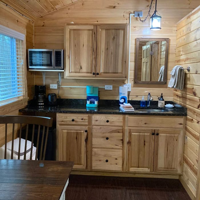 A compact wooden kitchenette with basic appliances and a small dining area.