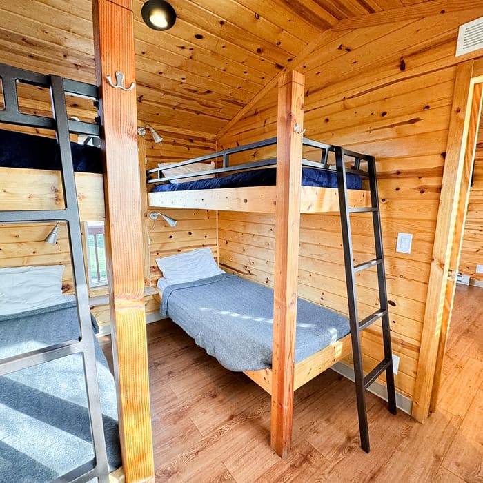 A simple wooden bunk bed setup in a cozy, rustic cabin room.
