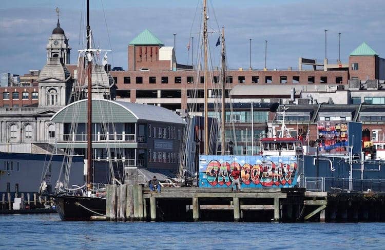 A boat docked at a Portland Maine dock with coastal charm in the background.