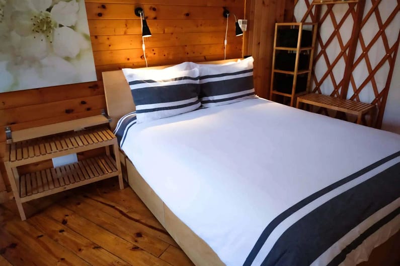 A bed or beds in a room with wooden walls.