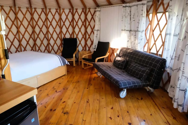 A yurt with a couch and a bed.