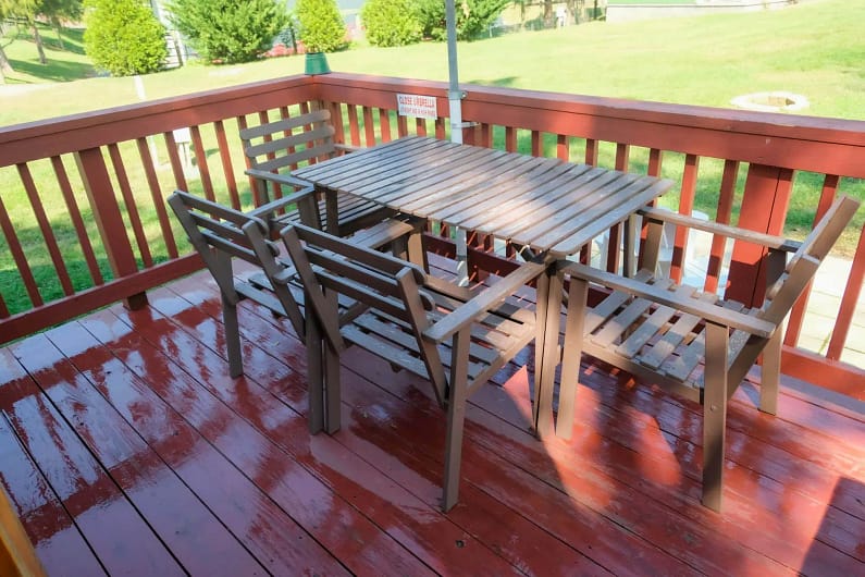 A table and chairs on the deck of a cabin.
