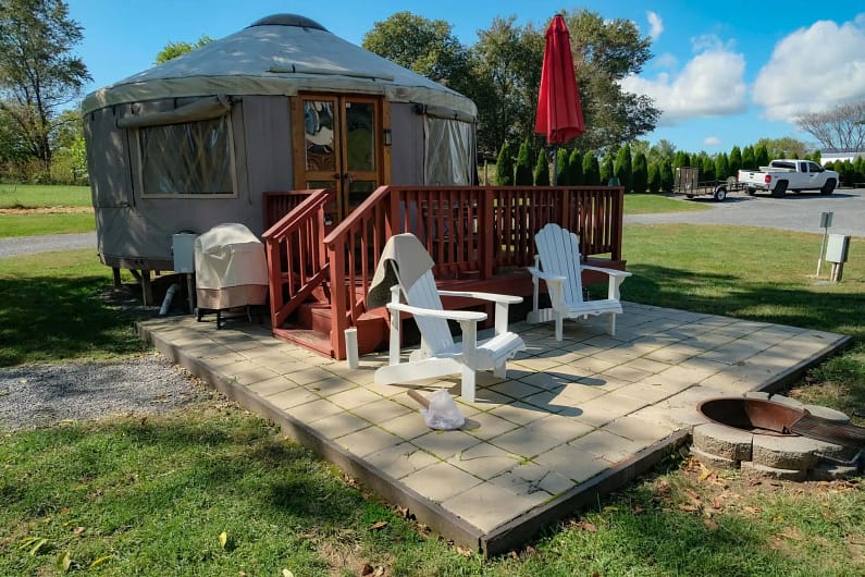 A white chairs on a patio next to a yurt.
