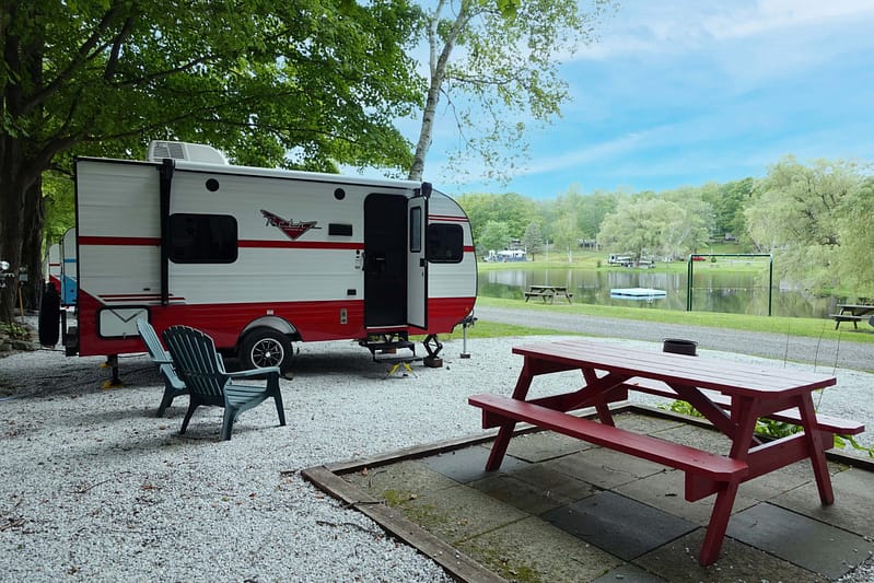 rv camping next to picnic table and lake