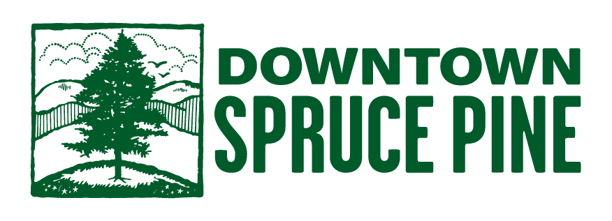 Discover the charming logo featuring a green tree illustration on a hill, framed by majestic mountains and clouds. Before you visit, know that "Downtown Spruce Pine" is displayed in bold capital letters to the right of the image.