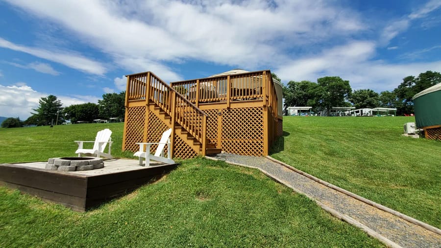 A deck with a fence and a walkway in a grassy field.