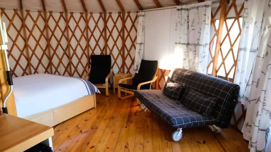 A yurt with a couch and a bed.
