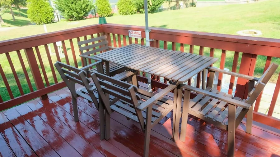 A table and chairs on the deck of a cabin.