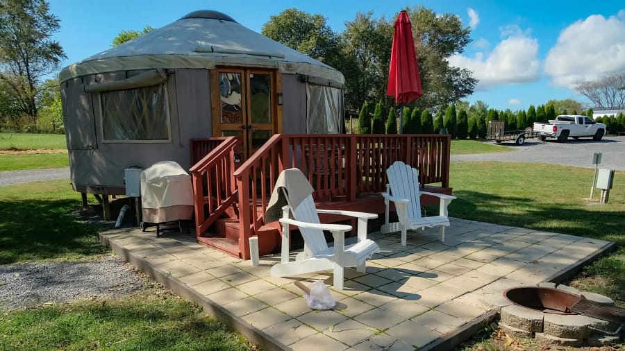 A white chairs on a patio next to a yurt.
